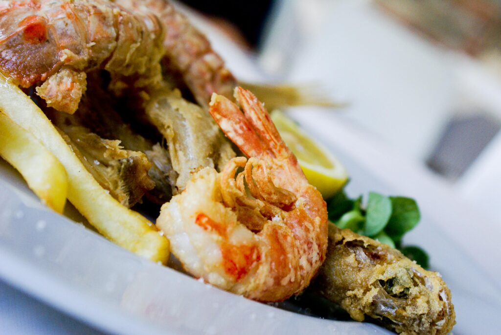 pexels-photo-921369-921369 Delicious fried seafood with fries, lemon wedge, and greens on a plate.